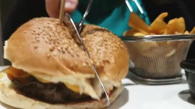 Domates sos, marul ve kaşar peyniri ile tahıl topuz yarısı angus burger kesilmiş. 