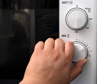 El siyah bir kapı ile beyaz mikrodalga fırın zamanlayıcı 5 dakika için zaman ayarlar