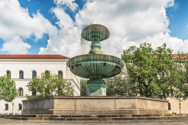 Münih, Almanya 09 Haziran 2018: Münih Geschwister-Scholl-Platz çeşmesi. Münih Ludwig Maximilian Üniversitesi'nde turistler. Üniversite, Almanya'nın en eski üniversiteleri arasındadır..