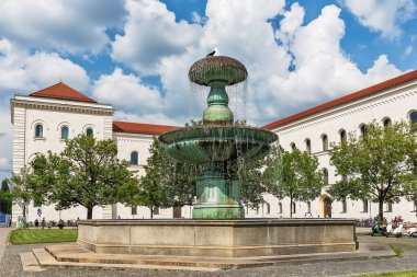 Münih, Almanya 09 Haziran 2018: Münih Geschwister-Scholl-Platz çeşmesi. Münih Ludwig Maximilian Üniversitesi'nde turistler. Üniversite, Almanya'nın en eski üniversiteleri arasındadır..