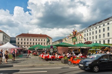 Münih, Almanya 09 Haziran 2018: Wittelsbacher Platz'da geleneksel ortaçağ pazarı ve Münih'te Elector Maximilian I'in Binicilik Heykeli. İnsanlar Alman geleneklerine göre yiyip içiyorlar..