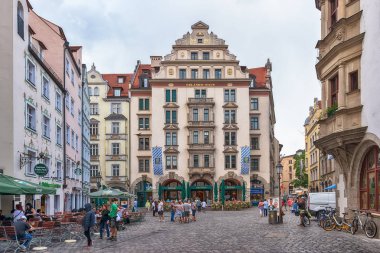 Münih, Almanya - 09 Haziran 2018: Münih'teki Orlando-Haus'un önündeki bir restoranda turistler. Ev Max Littmann tarafından 1899 yılında inşa edilmiştir. Foto Orlando-Haus görünümünde Platzl alınan