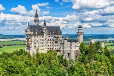 Hohenschwangau, Almanya - 10 Haziran 2018: Bavyera Alpleri'ndeki bir dağın tepesinde yer alan pastoral Neuschwanstein Kalesi. Bavyera Kralı Ludwig Ii tarafından yaptırılmıştır.