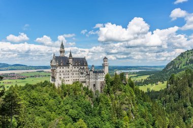 Hohenschwangau, Almanya - 10 Haziran 2018: Bavyera Alpleri'ndeki bir dağın tepesinde yer alan pastoral Neuschwanstein Kalesi. Bavyera Kralı Ludwig Ii tarafından yaptırılmıştır.