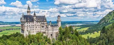 Hohenschwangau, Almanya - 10 Haziran 2018: Bavyera Alpleri'ndeki bir dağın tepesinde yer alan pastoral Neuschwanstein Kalesi. Bavyera Kralı Ludwig Ii tarafından yaptırılmıştır.