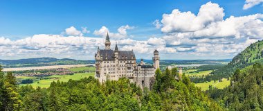 Hohenschwangau, Almanya - 10 Haziran 2018: Bavyera Alpleri'ndeki bir dağın tepesinde yer alan pastoral Neuschwanstein Kalesi. Bavyera Kralı Ludwig Ii tarafından yaptırılmıştır.
