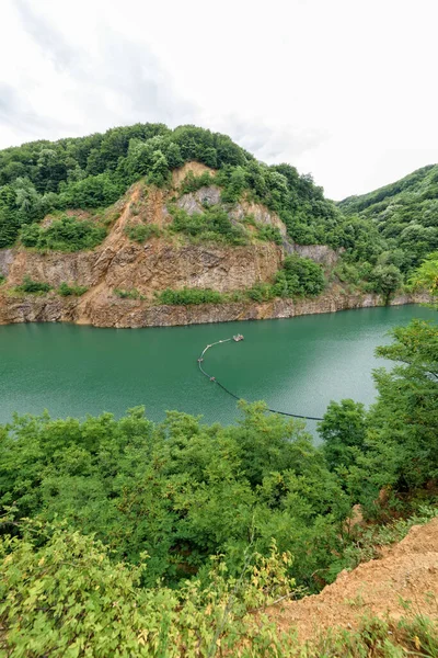 Beautiful Lake Ledinci (serbian: Ledinacko jezero) near Fruska Gora in Serbia, once there was a stone pit. Beautiful vibrant green deep mountain lake, hidden and surrounded by rocks and woods.