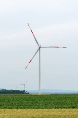 Elektrik üretimi için yel değirmenleri. Gündüz vakti Sırbistan kırsalında açık bir arazide yüksek açılı rüzgar türbinleri görüntüsü