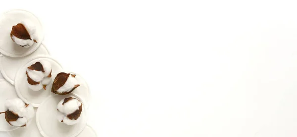 Pembe arka planda organik pamuklar. Sıfır atık, yeniden kullanılabilir, eko, makyaj temizleyici ve çamaşır konsepti. Desen, sert ışık, düz yatış, telif alanı, afiş.