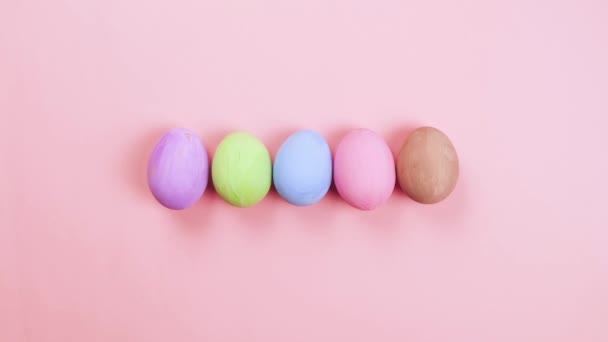 Праздником Пасхи Остановите Анимацию Красочные Яйца Появляются Ряд Розовом Фоне — стоковое видео