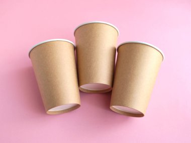 Pembe arka planda tek kullanımlık kağıt bardak. Ekoloji, plastik çevre kirliliği, atık geri dönüşümü kavramı. Düz çizgi
