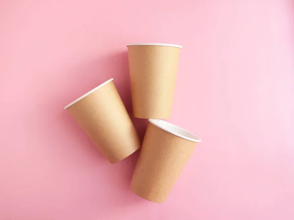 disposable paper cup on pink background. ecology, environmental pollution by plastic, waste recycling concept. copyspace.