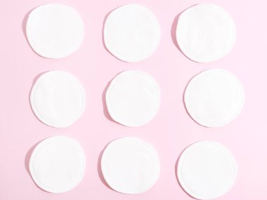 Pembe arka planda organik pamuklar. Sıfır atık, yeniden kullanılabilir, eko, makyaj temizleyici ve çamaşır konsepti. Desen, sert ışık düzlüğü.