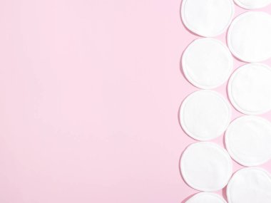 Pembe arka planda organik pamuklar. Sıfır atık, yeniden kullanılabilir, eko, makyaj temizleyici ve çamaşır konsepti. örüntü, sert ışık, düz yatış, kopyalanma alanı.