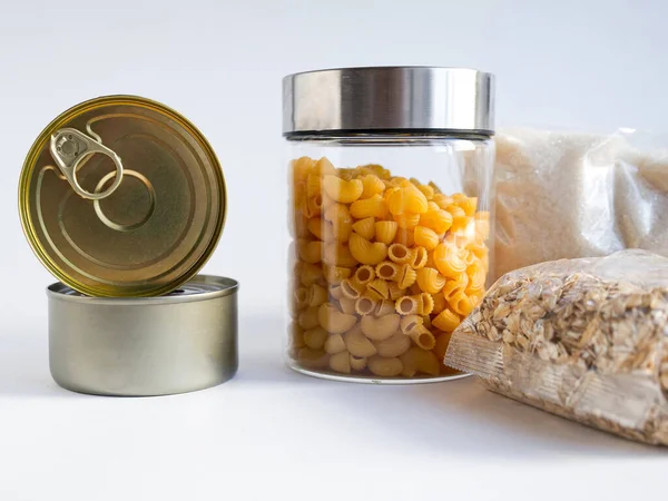 Kuru yiyecekler, stoklar, ev konsepti için gıda malzemeleri. Konserveler, makarna, yulaf ezmesi, beyaz arkaplanda şeker