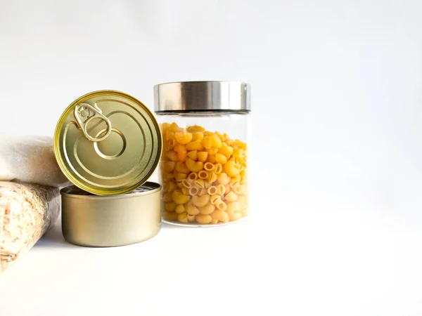 Kuru yiyecekler, stoklar, ev konsepti için gıda malzemeleri. Konserveler, makarna, yulaf ezmesi, beyaz arkaplanda şeker, telif alanı