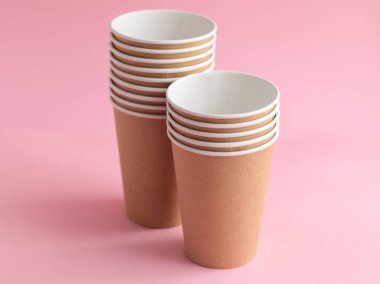 Pembe arka planda tek kullanımlık kağıt bardak. Ekoloji, plastik çevre kirliliği, atık geri dönüşüm kavramı