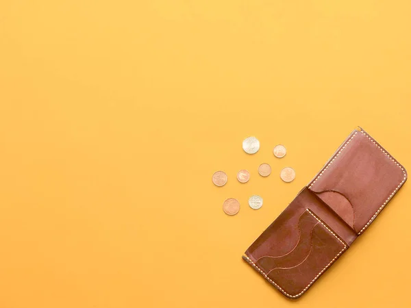 Kahverengi cüzdan, dağınık dolar ve sarı arka planda avro paraları. Son para, yoksulluk, işsizlik, iş kaybı, tasarruf kavramı. Düz konum, telif alanı.
