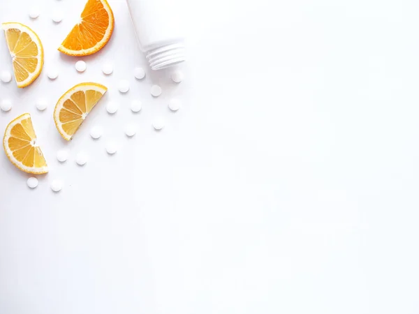 Beyaz arka planda limon portakallı vitamin hapları ve şişe. Telif uzayı, düz yatış. Bağışıklık sistemini, ilacı ve tabletleri güçlendirme kavramı