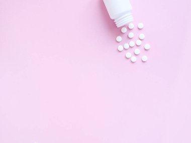 Pembe arka planda şişeden alınmış vitamin hapları. Telif uzayı, düz yatış. Bağışıklık sistemini, ilacı ve tabletleri güçlendirme kavramı