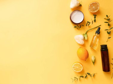 Krem, losyon, yağ, çiçek, turunçgil ve sarı arka planda okaliptüs içeren yassı beste. Güzelliği kavramsal olarak doğal vitamin kozmetik ürünü, cilt bakımı, telif alanı, üst görünüm