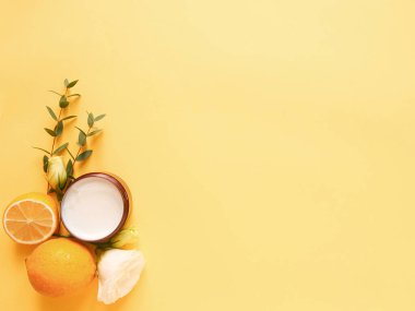 Sarı arka planda kremalı, çiçekli, turunçgilli ve okaliptüslü beste. Güzelliği kavramsal olarak doğal vitamin kozmetik ürünü, cilt bakımı, telif alanı, üst görünüm