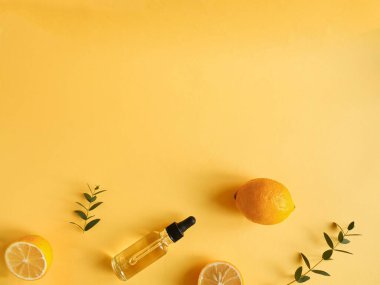 Sarı arka planda yağ, turunçgil ve okaliptüs içeren parlak düz bir kompozisyon. Güzelliği kavramsal olarak doğal vitamin kozmetik ürünü, cilt bakımı, telif alanı, üst görünüm
