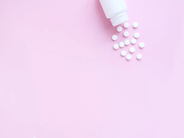 Pembe arka planda şişeden alınmış vitamin hapları. Telif uzayı, düz yatış. Bağışıklık sistemini, ilacı ve tabletleri güçlendirme kavramı