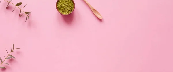 Küçük kavanozda kibrit çayı, tahta kaşık ve pembe arka planda okaliptüs yaprağı. Sağlıklı içeceği, kopyalama alanını, düz yatağı, üst görünümü, çerçeveyi, pankartı kavramsallaştır