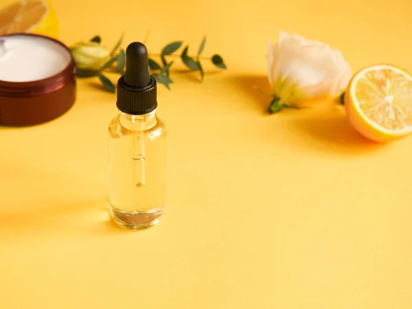 Sarı arka planda krema, yağ, çiçek, narenciye ve okaliptüs içeren parlak bir kompozisyon. Güzelliği kavramsal olarak doğal vitamin kozmetik ürünü, cilt bakımı, kopyalanma alanı, kapat
