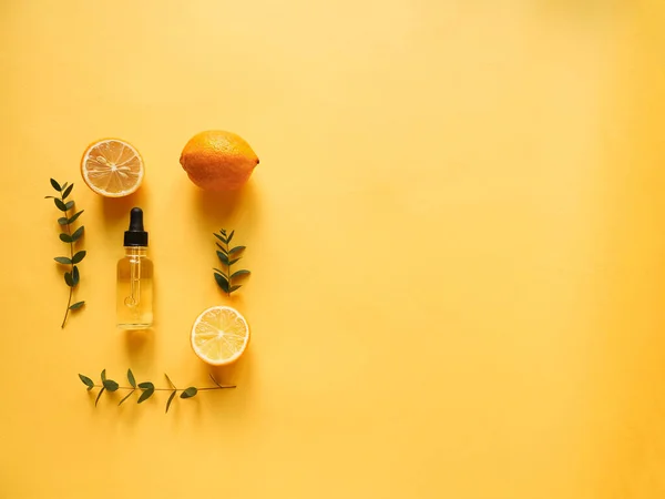 Sarı arka planda yağ, turunçgil ve okaliptüs içeren parlak düz bir kompozisyon. Güzelliği kavramsal olarak doğal vitamin kozmetik ürünü, cilt bakımı, telif alanı, üst görünüm