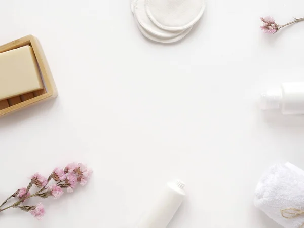 Krem, losyon, pamuk, bitki, sabun, havlu. Beyaz arka planda banyo aksesuarları, üst manzara, telif alanı. Ev konseptinde vücut bakımı güzellik tedavileri, organik ürünler, sabah rutini.