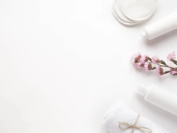 Krem, losyon, pamuk, bitki, havlu. Beyaz arka planda banyo aksesuarları, üst manzara, telif alanı. Ev konseptinde vücut bakımı güzellik tedavileri, organik banyo ürünleri, sabah rutini.