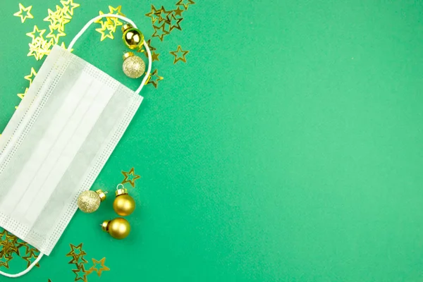 クリスマスの装飾が施された緑の背景のフェイスマスク コンセプト医療 雰囲気 お祝い グリーティングカード上のクリニックの仕事 フラットレイ トップビュー コピースペース — ストック写真