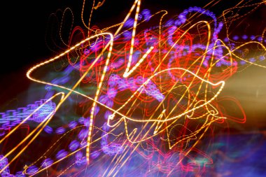 Hareketteki siyah arkaplanda renkli ışık vuruşları