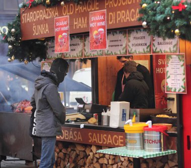 PRAG, CZECH REBUPLIC - 6 Ocak 2014: Noel pazarında sosisli sandviç alan adam