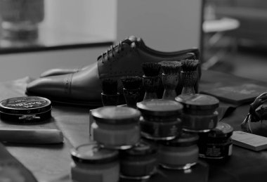 MOSCOW, Rusya - 25 Nisan 2017. Erkek ayakkabısı, üzerinde ayakkabı cilası ve fırça olan kavanozlar. Seçici odak noktasını siyah ve beyaz renkle kapat. Geriye dönük ruh hali