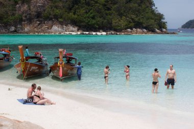 KOH RAWI, THAILAND - 22 Şubat 2017: Turistler dinleniyor ve beyaz kumsalda selfie çekiyorlar