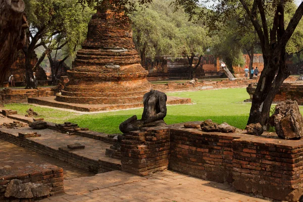 Tapınağın yıkıntıları arasında başsız Buddah heykeli