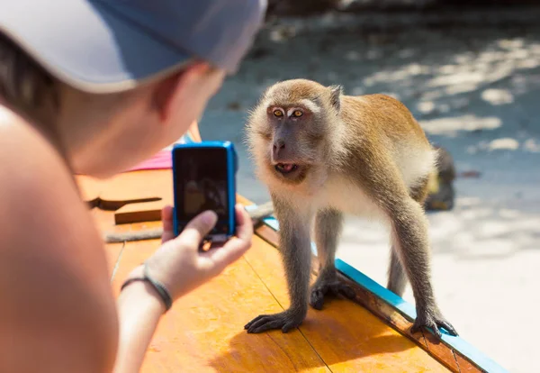 소녀는 원숭이가 보트에 사진을 찍는다 여행을 관광객들은 원숭이 사진을 찍는다 로열티 프리 스톡 이미지