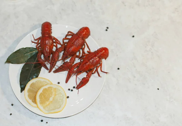 Üç kırmızı pişmiş kerevit ile lezzetli yemek, limon dilimleri ile 