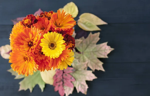 A beautiful  bouquet of orange autumn flowers stands in a vase o — Stock Photo, Image