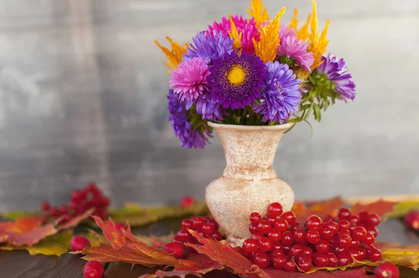 Bright autumn purple and yellow flowers in a vase stand on the t — Stock Photo, Image