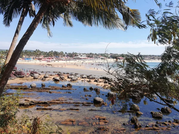 Ensolarado praia rochosa arenosa no norte de Goa Índia com pedras pretas — Fotografia de Stock