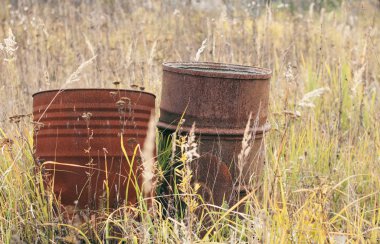  Paslı, eski, çürümüş metal variller sokakta duruyor.