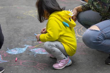 Açık park katta Çocuk, tebeşir mutlu karalamalar çizim