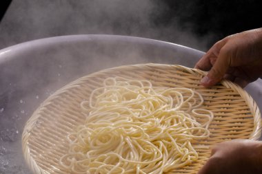 Bambu direği kazandaki sıcak erişteleri alır ve erişte dişlerinin iştahı vardır.