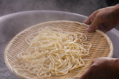 Bambu direği kazandaki sıcak erişteleri alır ve erişte dişlerinin iştahı vardır.