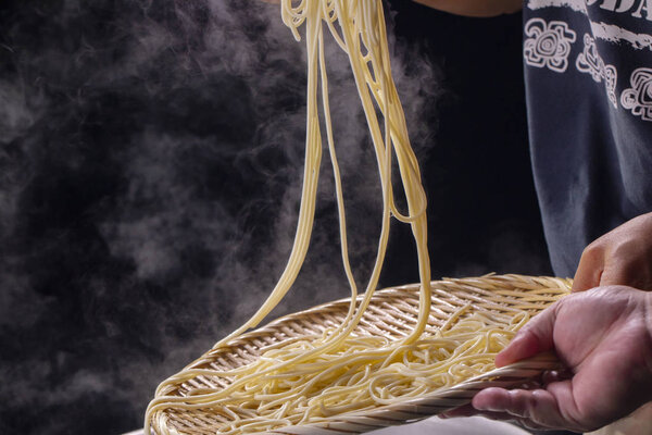 The bamboo pole picks up the hot noodles in the cauldron, and the noodle teeth have an appetite