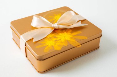 Sonbahar ortası festivali, beyaz arka planda saten kurdeleyle süslenmiş altın hediye kutusu.